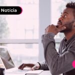Jovem olhando para tela de computador com expressão de dúvida.