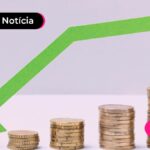 Seta verde apontando para baixo e moedas empilhadas.