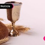 Taça dourada e pão ao lado.