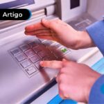 Pessoa sacando dinheiro em caixa eletrônico.