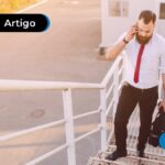 Pessoa com roupa social falando ao telefone e subindo escadas.