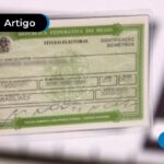 Mão segurando título de eleitor.