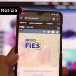 Pessoa segurando celular em site do FIES.