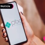 Mão segurando celular com ilustração do PIX na tela.