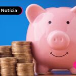 Cofre rosa em formato de porquinho e moedas empilhadas ao lado.