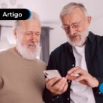 Duas pessoas de mais idade olhando para um celular
