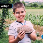 Criança sorrindo em área rural.