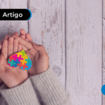 Pessoa segurando um coração com o símbolo do autismo