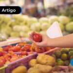 Pessoa segurando uma fruta, pensando no cartão alimentação.