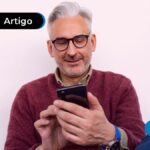 Pessoa de mais idade sorrindo vendo o celular