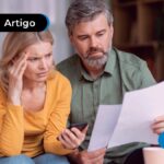 Dois adultos olhando para papel com expressão de preocupação.