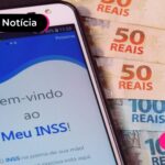 Celular com aplicativo do Meu INSS e notas de cinquenta reais.