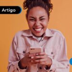 Pessoa sorrindo com o celular na mão