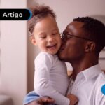 Pai segurando bebê sorrindo.