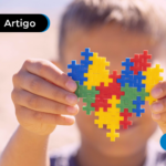 Criança segurando coração simbolo do autismo.