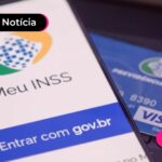 Celular com aplicativo do Meu INSS na tela e cartão de crédito ao lado.