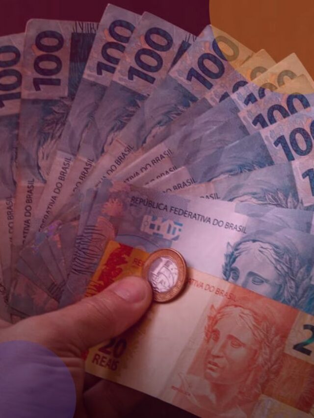 Pessoa segurando notas de cem e vinte reais