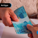 Pessoa entregando notas de cem reais para outra pessoa