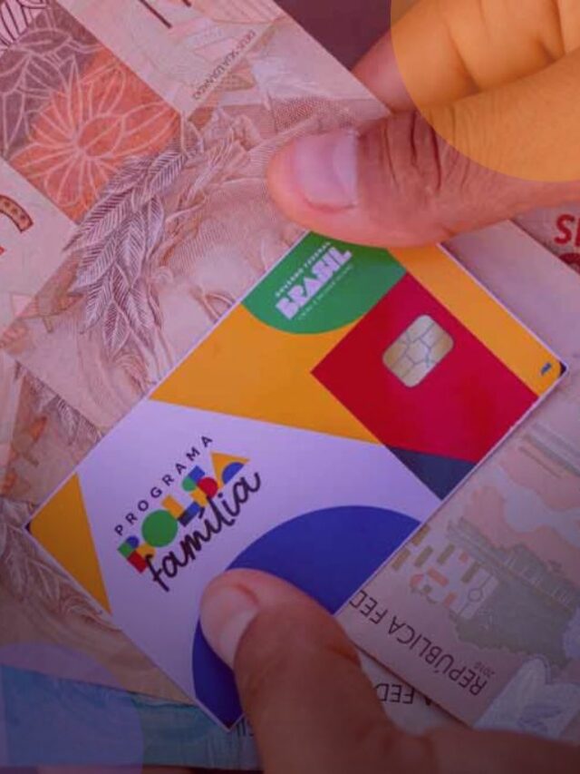 Pessoa segurando um cartão do Bolsa Família e cédulas