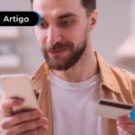 Pessoa lendo artigo sobre débito automático no celular.