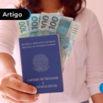 Pessoa segurando uma carteira de trabalho com cédulas de cem reais