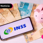 Notas de cinquenta e cem reais espalhadas em mesa com cofrinho e celular ao lado.