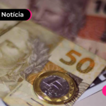 Notas de cinquenta e moedas espalhadas em mesa.
