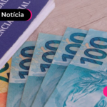 Notas de cem reais espalhadas em mesa e carteira de trabalho ao lado, simbolizando o pagamento do décimo terceiro salário em 2024.