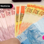 Pessoa com várias notas de dinheiro na mão.