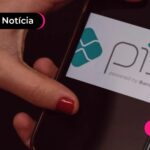Pessoa segurando o celular com a logo do Pix
