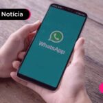 Pessoa segurando celular com WhatsApp na tela.