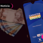 Celular com aplicativo do CadÚnico e notas de dinheiro no fundo.