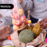 Pessoa retirando itens de cesta básica e colocando em mesa.