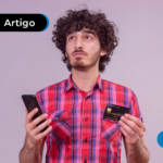 Pessoa segurando um cartão e um celular
