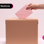 Pessoa colocando envelope em caixa de papelão.