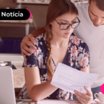 Duas pessoas vendo um papel de inadimplência