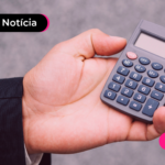 Mão segurando calculadora.