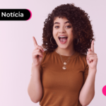 Pessoa sorrindo apontando com o dedo indicador para cima.