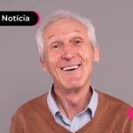 Pessoa de idade sorrindo após ler notícia sobre décimo terceiro dos aposentados.