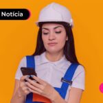 Trabalhadora CLT sorrindo enquanto lê notícias sobre o consignado privado.