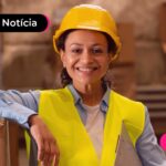 Trabalhadora com uniforme sorrindo após ler notícia sobre a possibilidade de negativados contratar consignado privado.