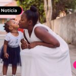Mãe abraçando filha bebê.
