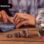 Homem calculando com moedas ao lado