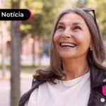 idosa com blusa branca feliz