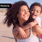 mulher feliz com seu filho nas suas costas