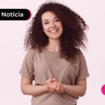 Mulher sorrindo com uma camisa bege