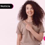 Jovem sorrindo após ler notícia sobre regras da portabilidade de consignado.