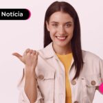 Mulher sorrindo em um fundo rosa.