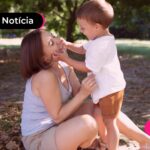 Pessoa brincando com criança em parque.