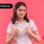 Jovem sorrindo enquanto usa fones de ouvido e lê notícia sobre consignado privado em Curitiba.